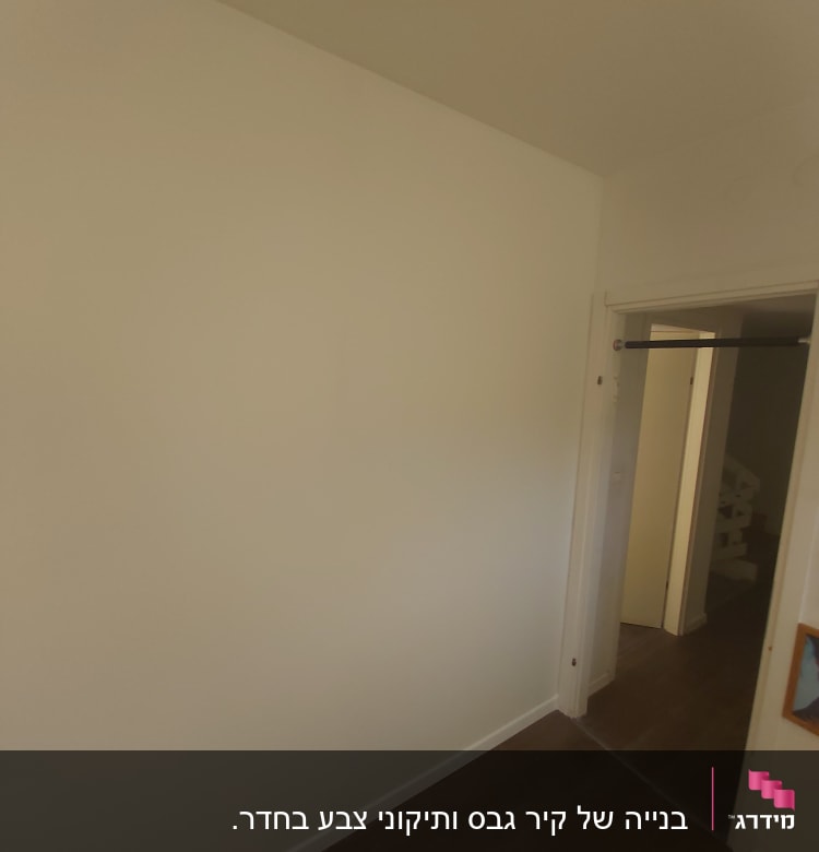 קיר גבס לבן עם דלת פתוחה בצד ימין